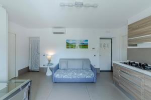 a kitchen with a blue couch in the middle of a room at Casa Mare & Relax in Pozzuoli