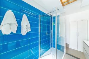 a blue tiled bathroom with a shower and towels at Casa Mare & Relax in Pozzuoli +23 photos