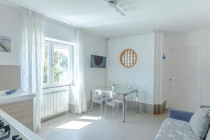 a white living room with a table and a window at Casa Mare & Relax in Pozzuoli