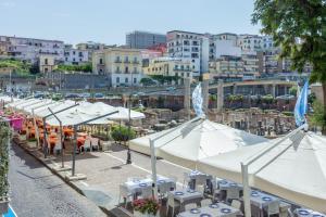 een rij tafels en parasols met tafels en stoelen bij Casa Mare & Relax in Pozzuoli