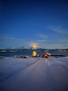 una casa en la orilla de un lago por la noche en Larseng Kystferie, en Larseng