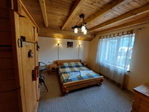 a bedroom with a bed in a room with a window at АртГір гостинний двір in Mykulychyn