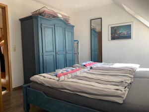 カロリーネンジールにあるFerienwohnung Muhlichenの青いキャビネット付きの大型ベッド1台が備わる客室です。