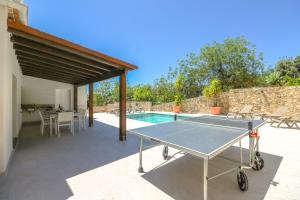 een tafeltennistafel op een patio naast een zwembad bij Villa Redonda in Loulé