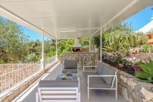 Villa Redonda في لولي: بريقولا أبيض مع الكراسي والطاولات على الفناء