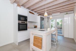 a kitchen with white cabinets and a counter with a sink at Rocco House By ALGARTUR in Tavira