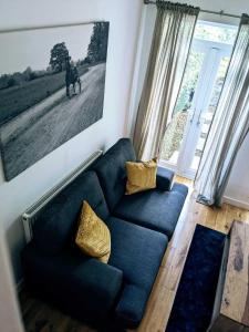 Cardiff 2 Bedroom Luxury House في كارديف: غرفة معيشة بها أريكة زرقاء و لوحة