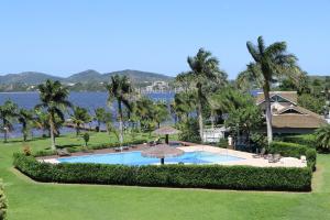 una vista aérea de una piscina con palmeras en Completo apartamento em Resort na beira da lagoa en Florianópolis