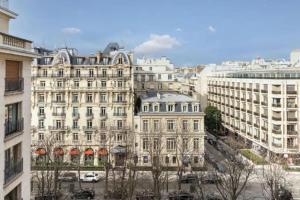 um grande edifício branco numa cidade com edifícios em Avenue Montaigne : Luxury Apartment 4P/2BR em Paris