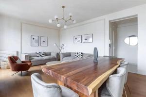 uma sala de estar com uma mesa de madeira e cadeiras em Avenue Montaigne : Luxury Apartment 4P/2BR em Paris