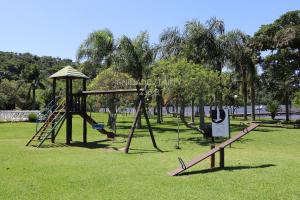 um parque com parque infantil com escorrega em Completo apartamento em Resort na beira da lagoa em Florianópolis