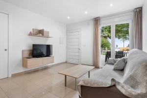 a living room with a couch and a tv at La Vida Sin Limites EMP in Empuriabrava