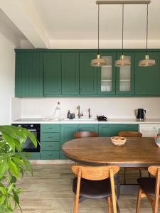 a kitchen with green cabinets and a wooden table at Loft with a cosy terasse in Limassol