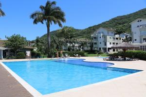 une piscine au milieu d'un complexe hôtelier dans l'établissement Completo apartamento em Resort na beira da lagoa, à Florianópolis