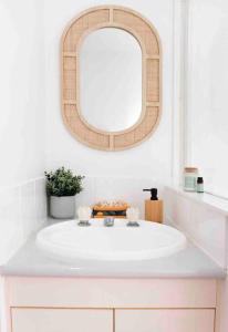uma casa de banho com um lavatório branco e um espelho. em Island Villas - Lady Musgrave - Unit 1 em Bundaberg
