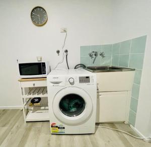 uma máquina de lavar roupa numa cozinha com um lavatório em Island Villas - Lady Musgrave - Unit 1 em Bundaberg