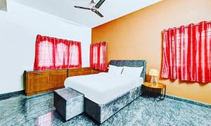 a bedroom with a white bed and red curtains at FabExpress Aathira Inn in Chennai