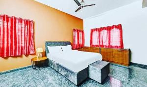 a bedroom with a white bed and red windows at FabExpress Aathira Inn in Chennai