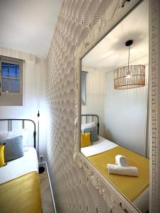 - une chambre avec un lit et un miroir sur le mur dans l'établissement Hypercentre Charmant 2 Chambres Au Calme avec Joli Patio Privatif, à Nantes