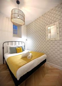 a bedroom with a bed and a chandelier at Hypercentre Charmant 2 Chambres Au Calme avec Joli Patio Privatif in Nantes