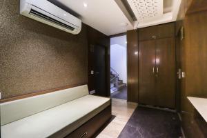 a small room with a couch and a air conditioner at Collection O Hotel Kyra in Ahmedabad