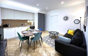 a living room with a couch and a table and a kitchen at Hypercentre Charmant 2 Chambres Au Calme avec Joli Patio Privatif in Nantes