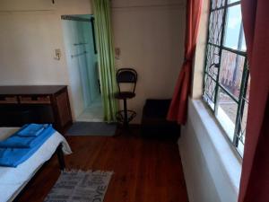 South End的住宿－The Bridge Lodge，一间卧室配有一张床、一张书桌和一个窗户。