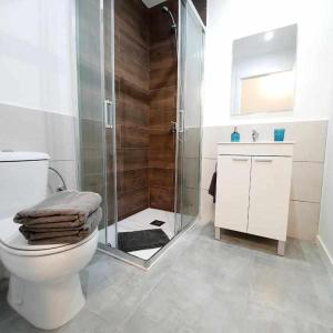a bathroom with a toilet and a glass shower at Hostal Urban Basic in Hospitalet de Llobregat