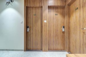two wooden elevator doors in a room at Hotel Archith in Navi Mumbai