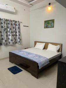 a bedroom with a large bed with a blue blanket at Leela home stay - Lotus (2 BHK luxury appartment) in Jabalpur