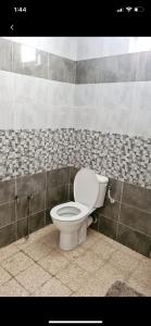 a bathroom with a toilet in a tiled wall at MB DREAMS DJERBA in Houmt Souk