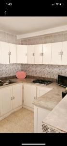 a kitchen with white cabinets and a pink bowl on the counter at MB DREAMS DJERBA in Houmt Souk