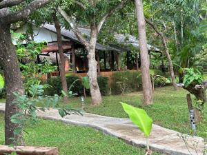 a path leading to a house with trees at Sigiriya Cottage in Sigiriya