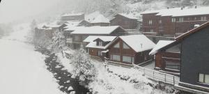 un grupo de edificios cubiertos de nieve en Cabaña de madera Vall D Incles Parking y Wifi Gratis, en Incles