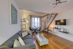 een woonkamer met een bank en een tafel bij Chaleureux duplex 30min de Paris in Corbeil-Essonnes