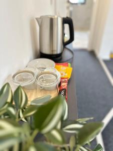 une table avec quatre bocaux vides et une cafetière dans l'établissement Royal Moon Suites, à Sarajevo