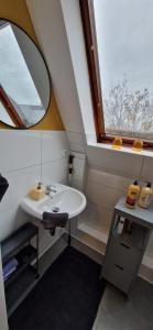 ein Bad mit einem Waschbecken, einem Spiegel und einem Fenster in der Unterkunft Central-Living yellow - Wifi - Netflix - City in Essen