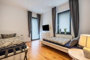 a bedroom with two beds and two windows at Casa Caso - Apartment 4 in Achim