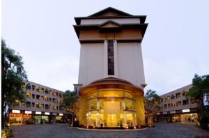 a large building with a clock tower in front of it at Maninarakorn Hotel in Chiang Mai