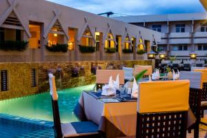 a restaurant with a swimming pool next to a building at Maninarakorn Hotel in Chiang Mai