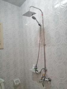 y baño con ducha con cabezal de ducha. en شقة الولاء Loyalty apartment, en Dumyāţ al Jadīdah