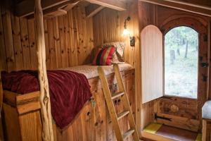 a bedroom in a log cabin with a bunk bed at Cal Serrat in Abella de la Conca