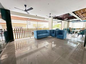 eine Lobby mit blauen Sofas, Tischen und Fenstern in der Unterkunft Skon Baga Bliss Hotel by Orion Hotels in Goa