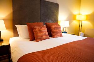 a hotel room with a large bed with pillows at Bicester Hotel, Golf & Spa in Bicester