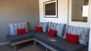 a blue couch with red pillows in a room at Fragateira in Aldeia de Brescos