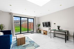 a living room with a desk and a tv at Stylish Sparkling Brand New 2 bed house in Heston