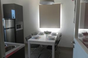 a kitchen with a white table with chairs and a refrigerator at Fragateira in Aldeia de Brescos