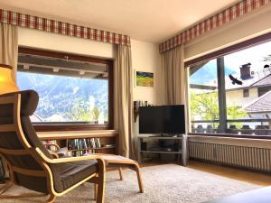 sala de estar con ventana grande y TV en Fewo Karwendelglühen, en Mittenwald