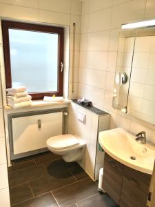 ミッテンヴァルトにあるFewo Karwendelglühenのバスルーム(トイレ、洗面台付)、窓が備わります。