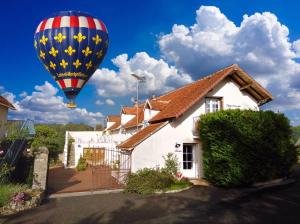 a hot air balloon flying over a house at Guest House "Près des Montgolfières" in Angé